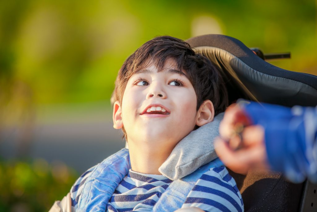 Young disabled boy in wheelchair looking up into sky