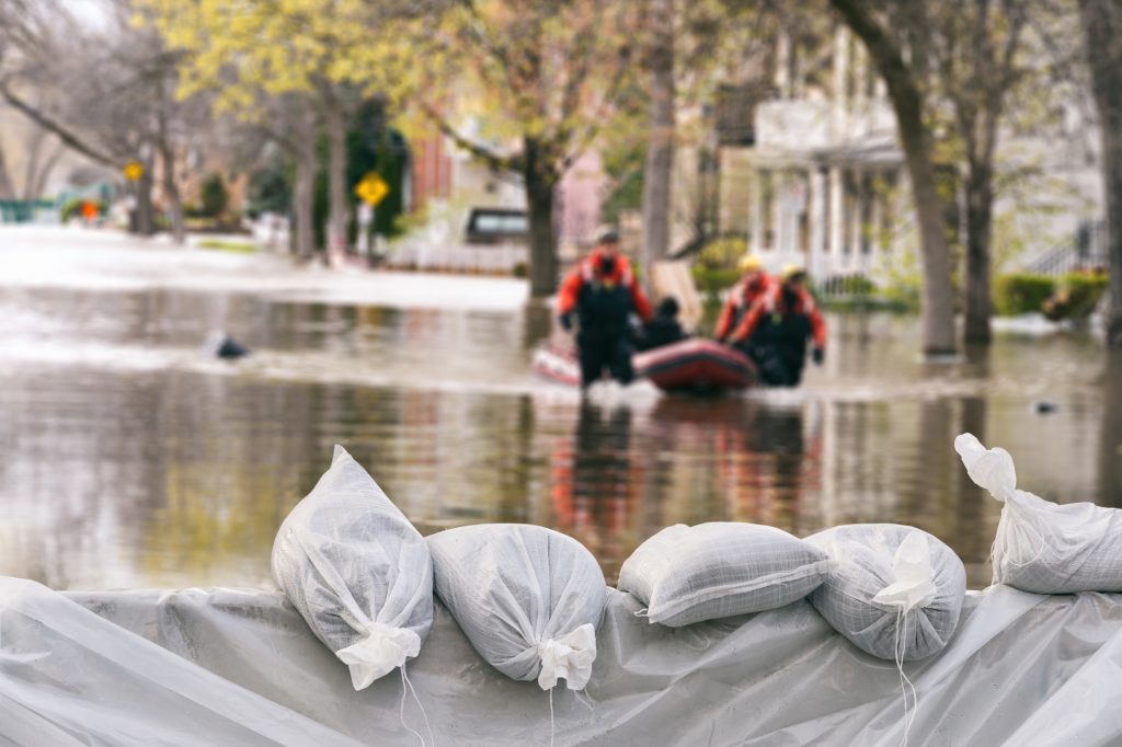 lood Protection Sandbags with flooded homes in the background (Montage)