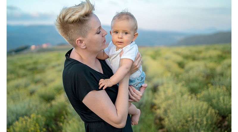 Mother holding baby in a rural field