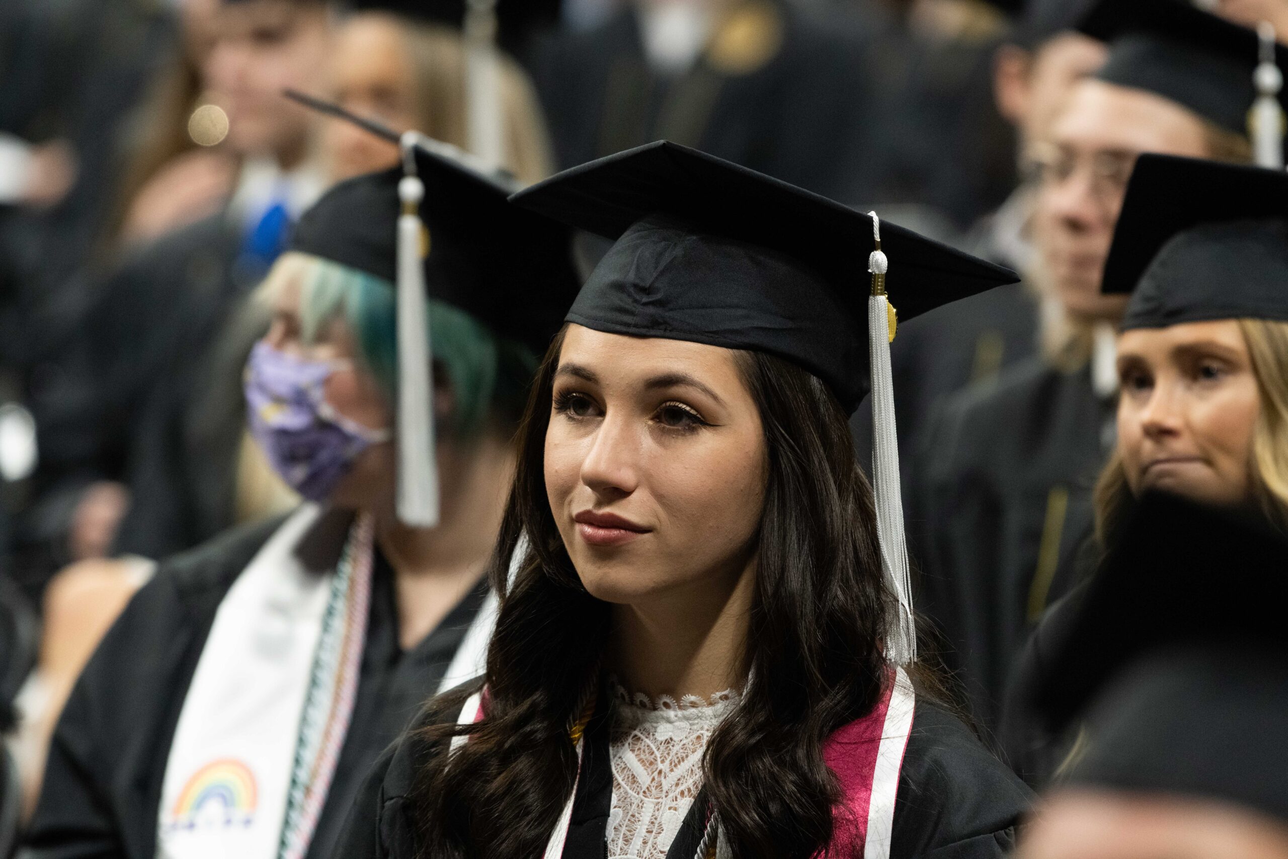 Graduate listening to speech at a commencement ceremony.