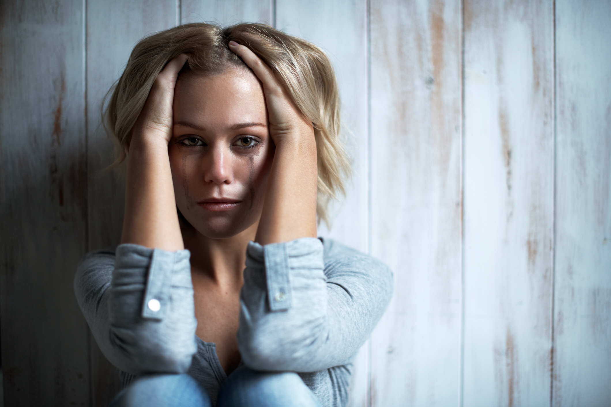 Portrait of a tearful young woman with her hand in her hair