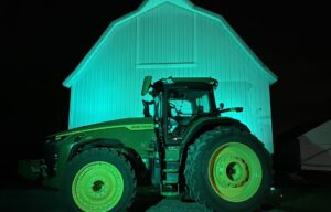 A green tractor in front of a barn (rural Mason City, Iowa) lighting up green for National Injury Prevention Day to raise awareness of the need to prevent injuries and violence in rural communities.