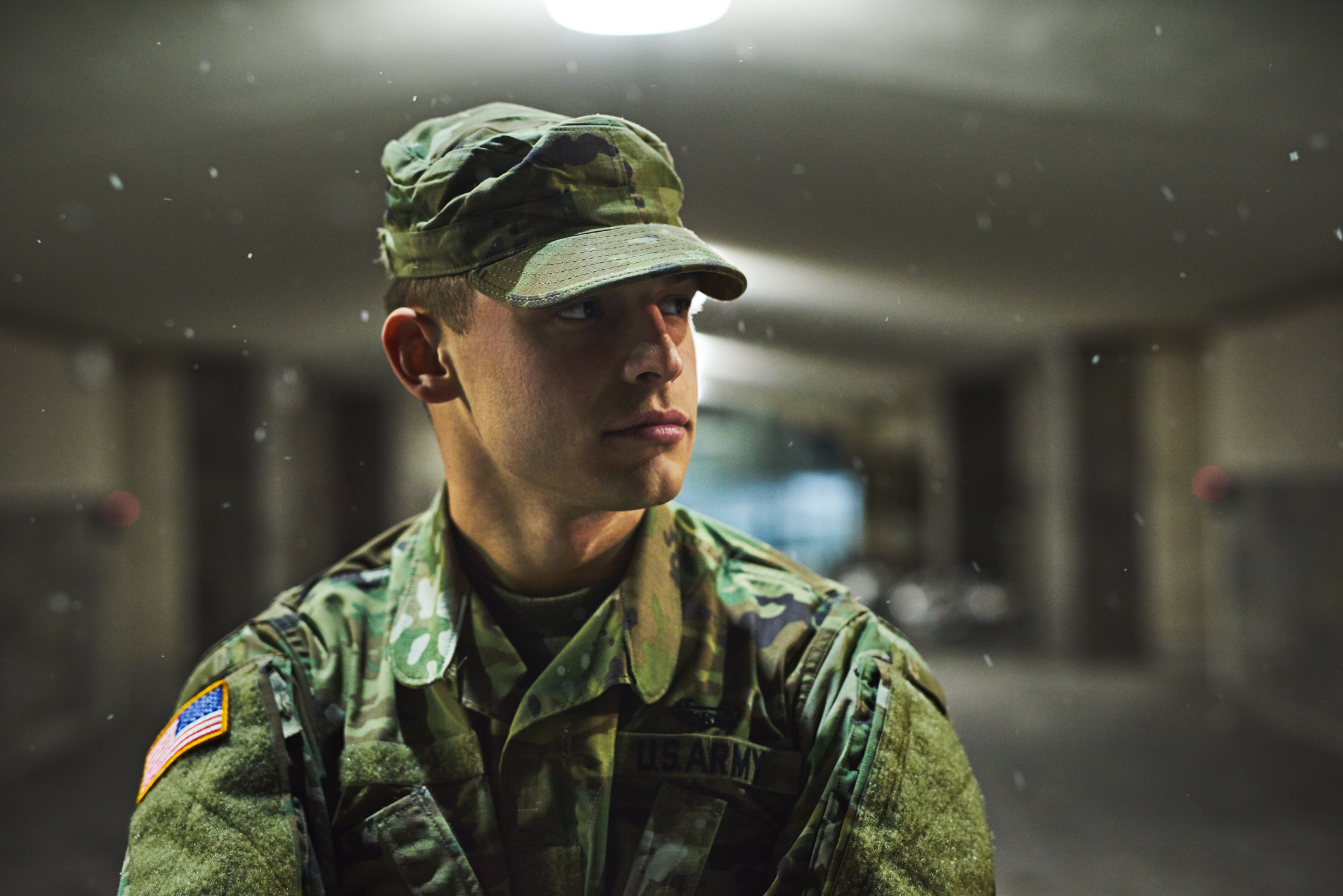  a young soldier standing outside on a cold night at a military academy