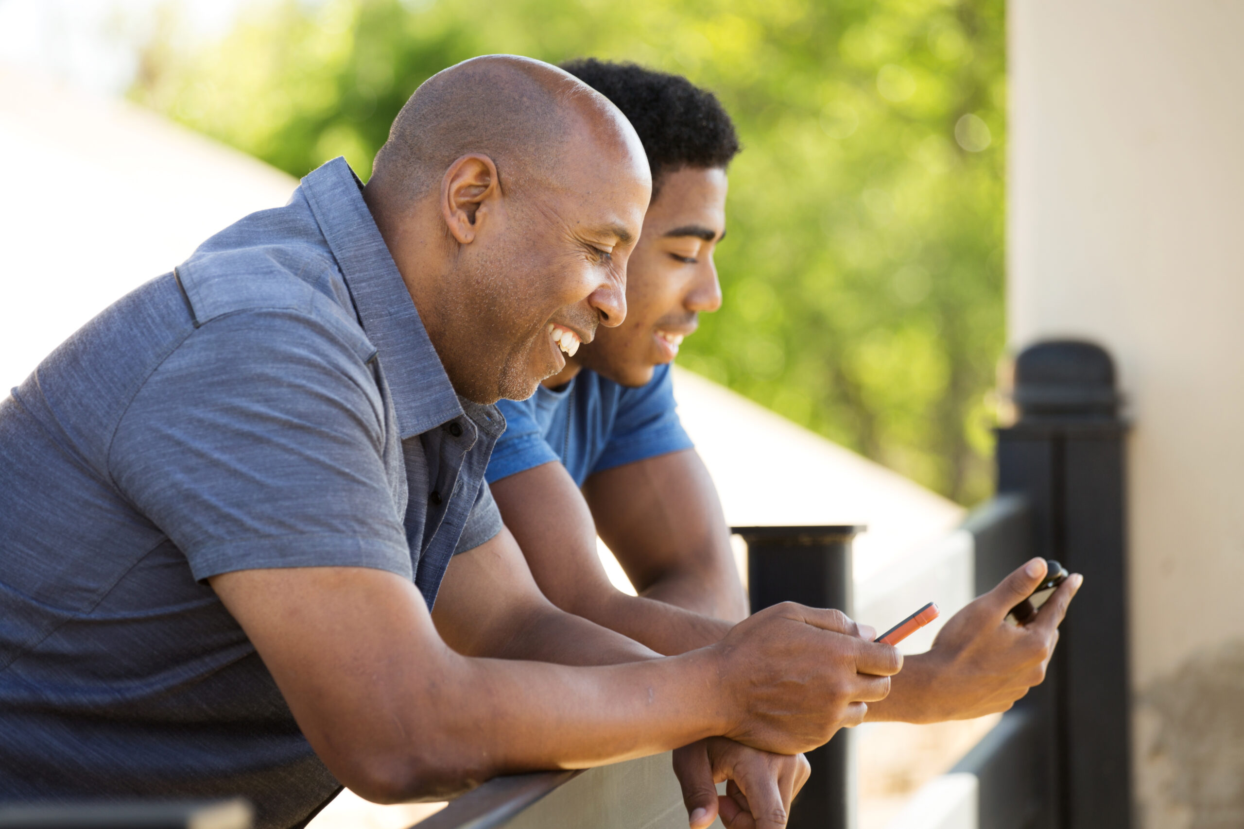 Father talking and texting on their mobile phone.