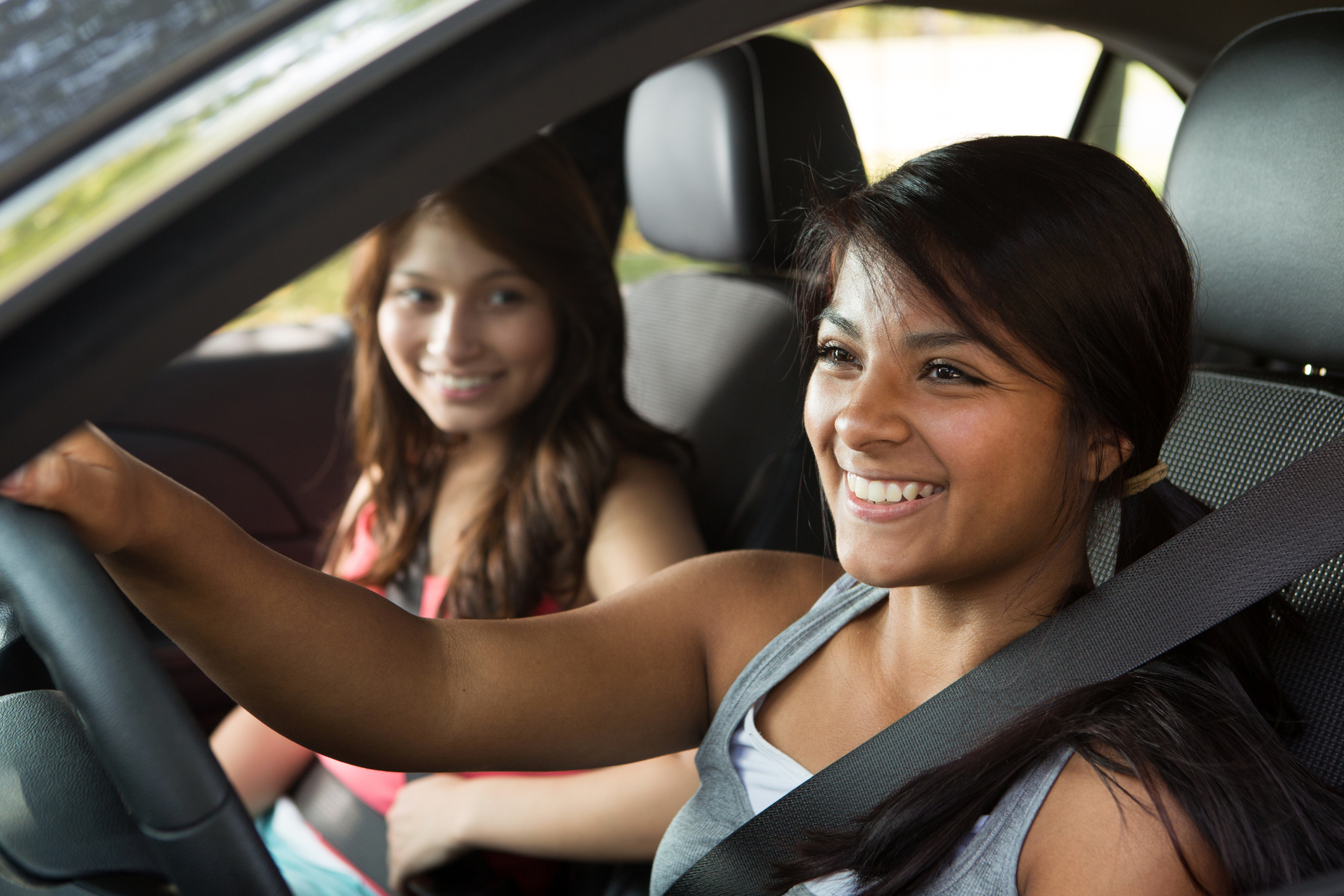 Female teen driver with female passenger in the front seat