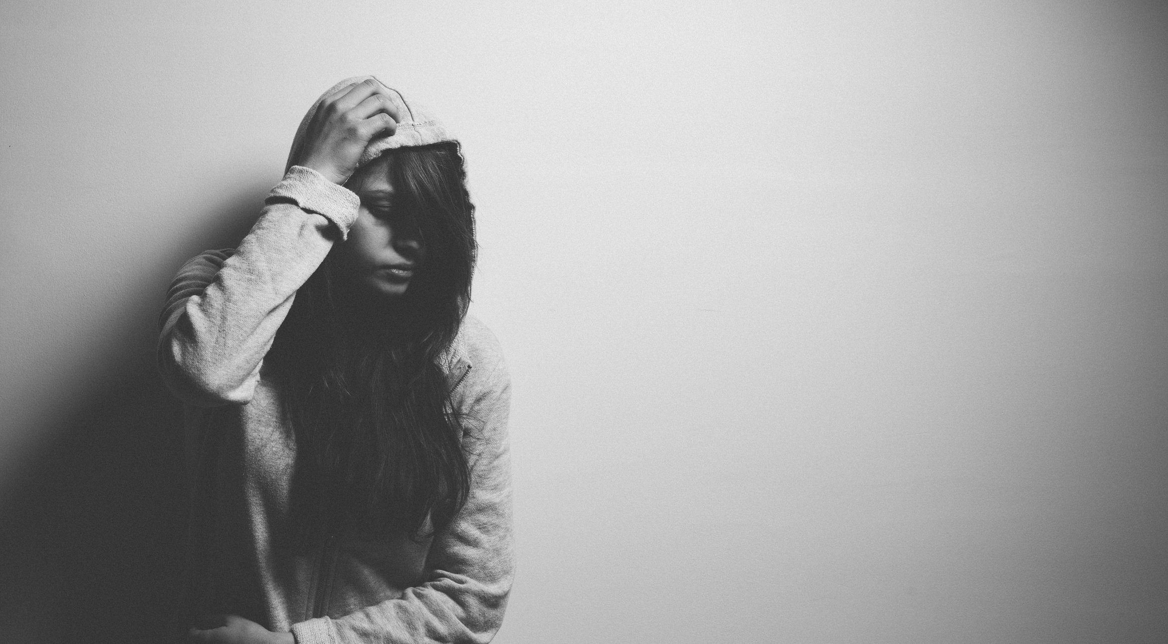 Sad teen girl looking to the side with her hair and her hood partially covering her face