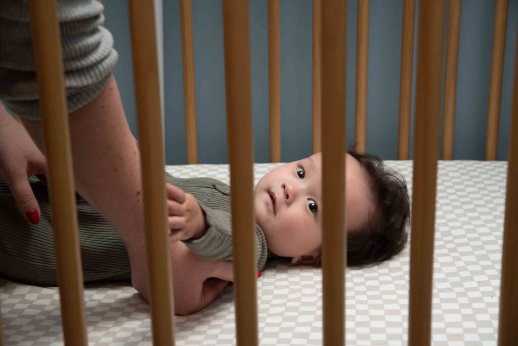 baby being placed in a crib