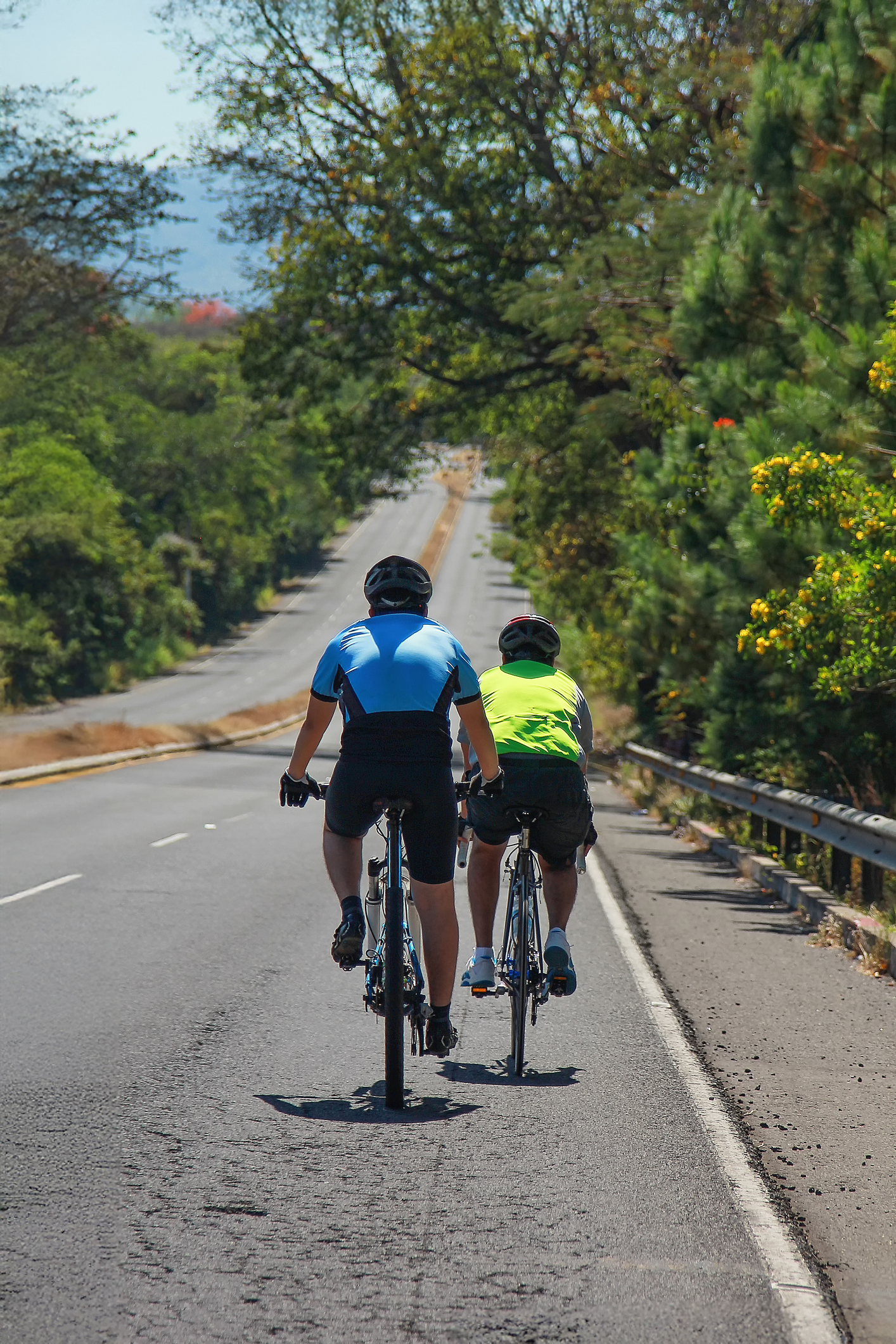 Two bicyclists riding on the road